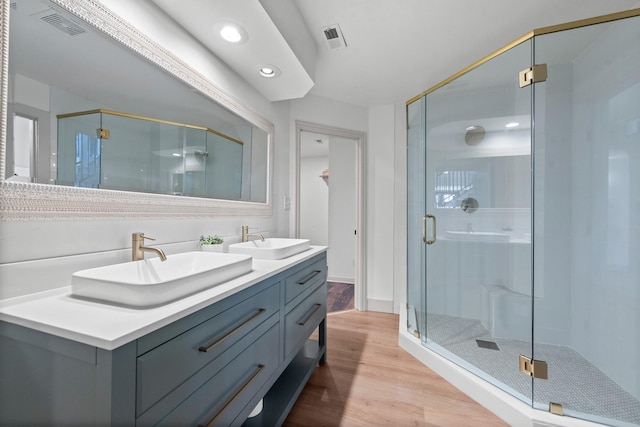 bathroom featuring vanity, wood-type flooring, and a shower with door