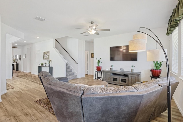 living room with ceiling fan and light hardwood / wood-style flooring