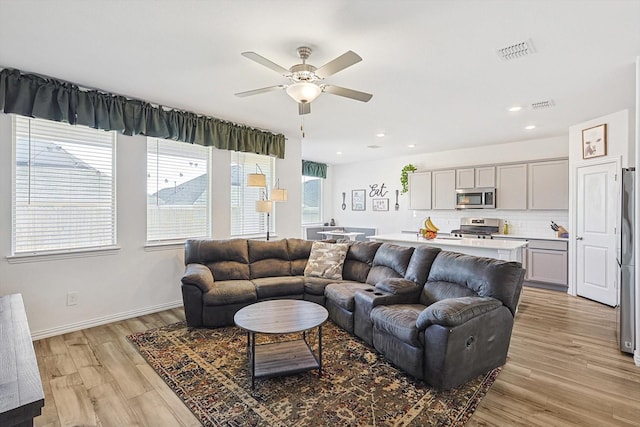 living room featuring ceiling fan and light hardwood / wood-style floors