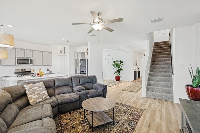 living room with ceiling fan and light wood-type flooring