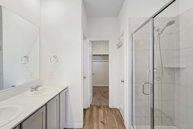 bathroom featuring an enclosed shower, vanity, and wood-type flooring