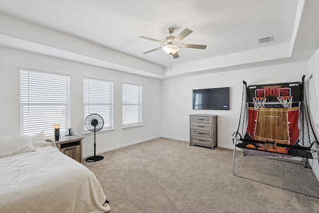 bedroom with a tray ceiling, carpet floors, and ceiling fan