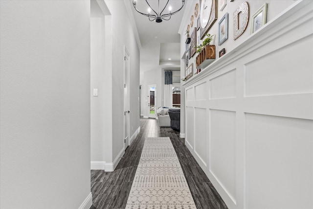 hallway featuring dark hardwood / wood-style flooring and a chandelier