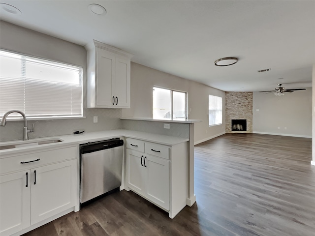 kitchen with dishwasher, sink, kitchen peninsula, and white cabinets