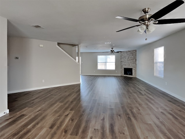 unfurnished living room with ceiling fan, dark hardwood / wood-style floors, and a fireplace