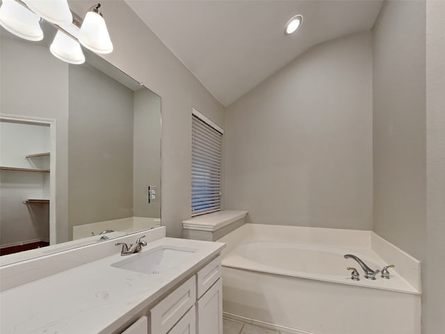 bathroom with vanity, vaulted ceiling, and a washtub