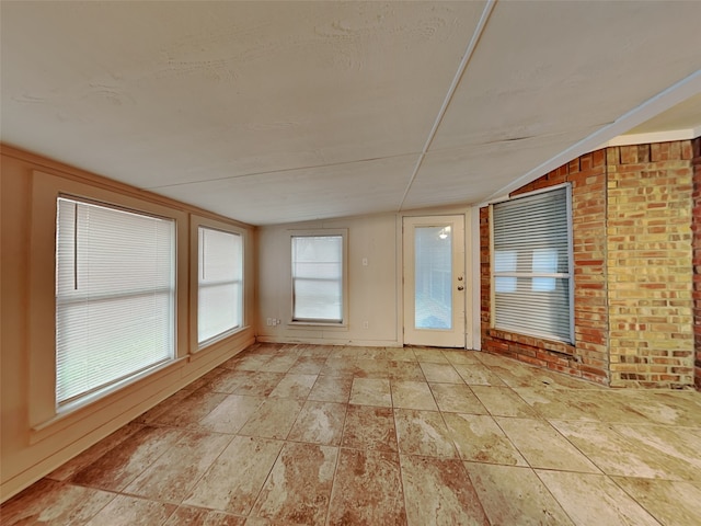 unfurnished sunroom featuring vaulted ceiling