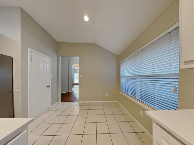 interior space with lofted ceiling and light tile patterned floors