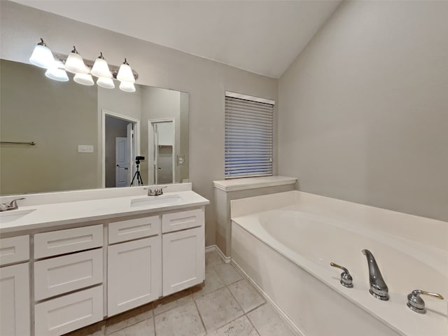 bathroom with lofted ceiling, vanity, tile patterned flooring, and a tub