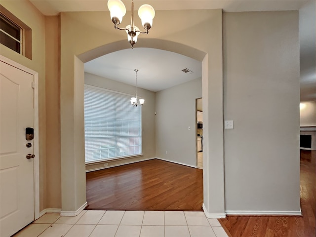 tiled entryway with an inviting chandelier