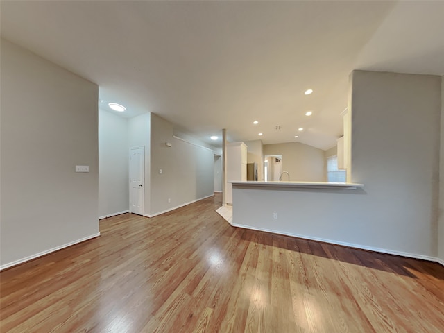 unfurnished living room with lofted ceiling and light hardwood / wood-style floors