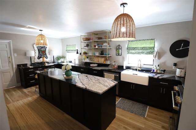 kitchen featuring sink, crown molding, light hardwood / wood-style floors, and a center island