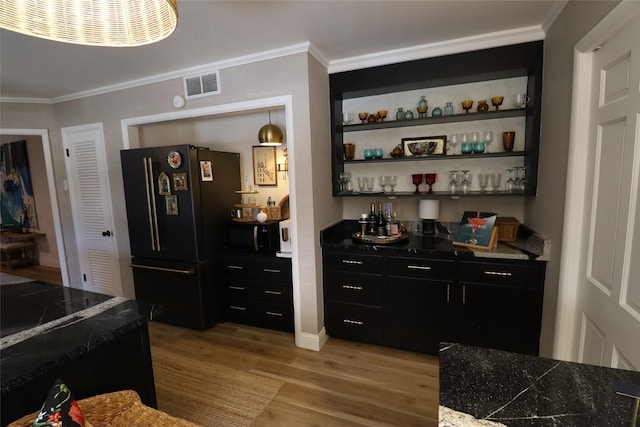 bar featuring crown molding, light wood-type flooring, and black appliances