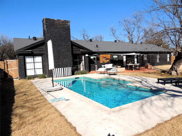 view of pool featuring a lawn and a patio