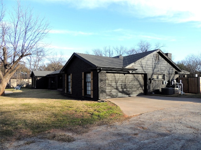 view of side of home with central AC, a garage, and a lawn