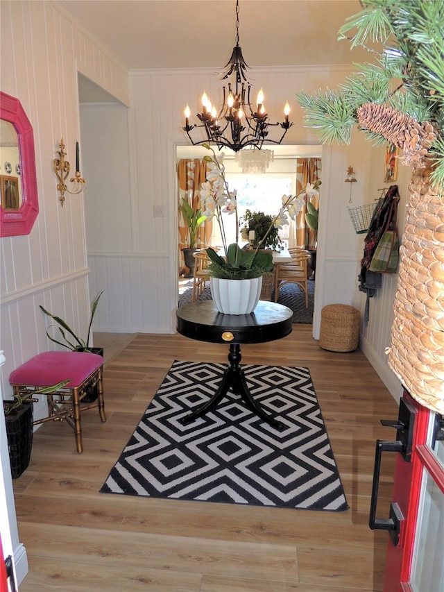 interior space featuring crown molding, a notable chandelier, and light wood-type flooring