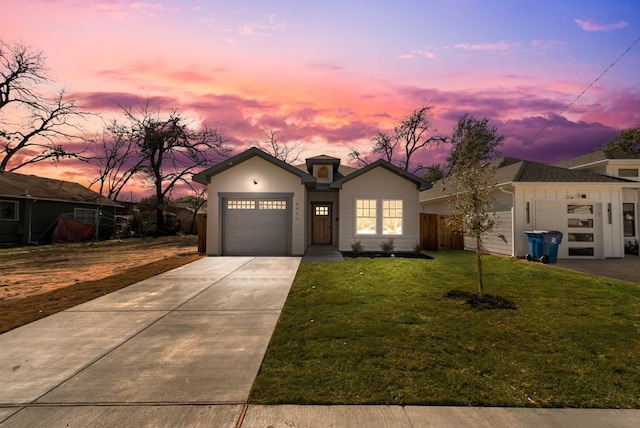 view of front of house featuring a garage and a lawn