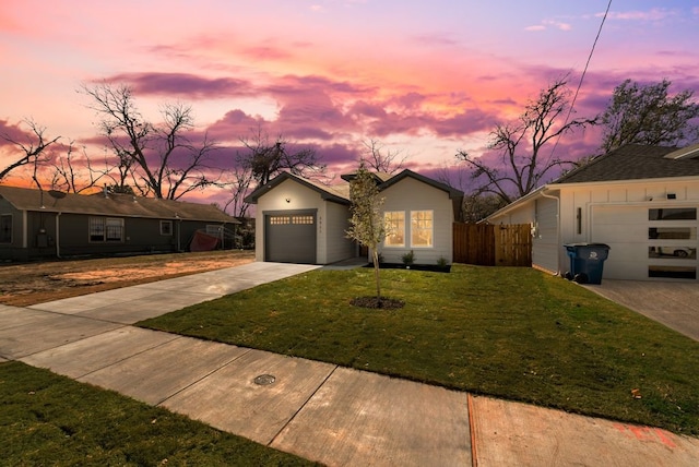 ranch-style home featuring a garage and a lawn