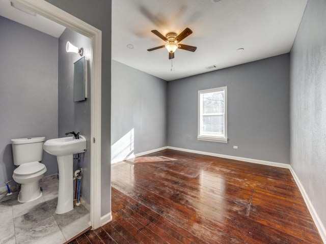 311 W Acheson St, Denison, TX 75020 - bathroom with hardwood / wood-style floors, sink, toilet, and ceiling fan