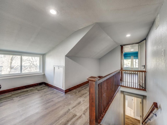311 W Acheson St, Denison, TX 75020 - bonus room featuring lofted ceiling, a wealth of natural light, a textured ceiling, and light hardwood / wood-style flooring