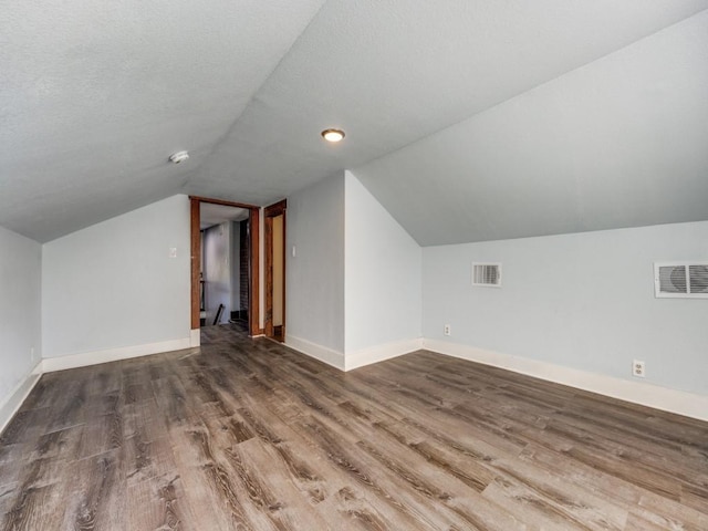 311 W Acheson St, Denison, TX 75020 - bonus room with wood-type flooring, a textured ceiling, and vaulted ceiling