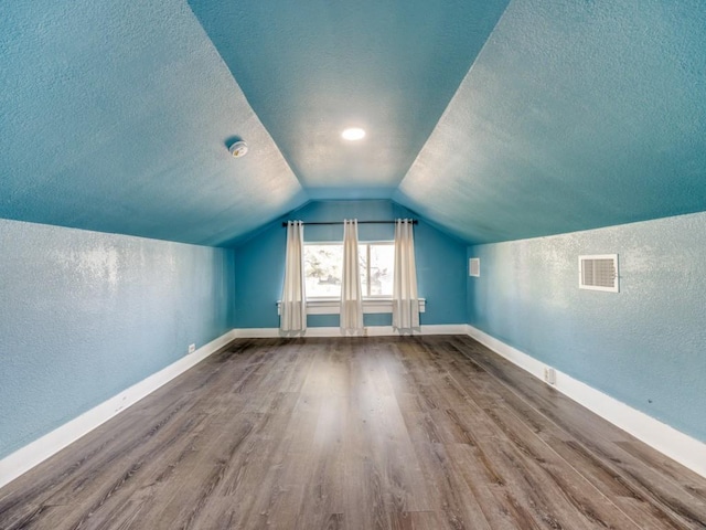 311 W Acheson St, Denison, TX 75020 - bonus room featuring hardwood / wood-style flooring, vaulted ceiling, and a textured ceiling