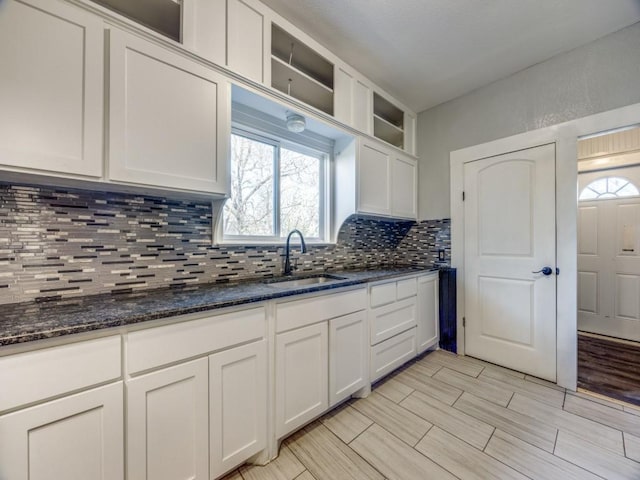 311 W Acheson St, Denison, TX 75020 - kitchen with sink, decorative backsplash, dark stone counters, and white cabinets