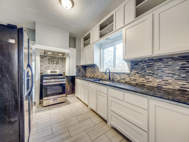 311 W Acheson St, Denison, TX 75020 - kitchen with sink, stainless steel range with gas stovetop, black refrigerator with ice dispenser, and white cabinets