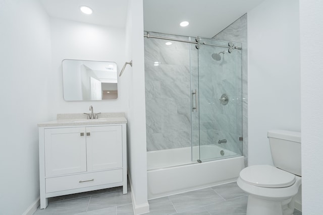full bathroom with enclosed tub / shower combo, vanity, and toilet