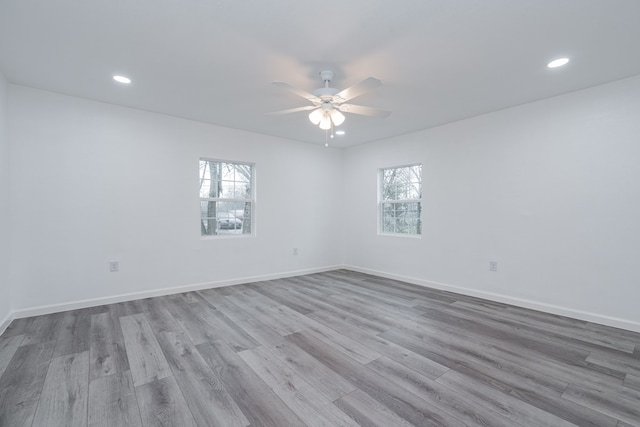 empty room with ceiling fan and light hardwood / wood-style floors