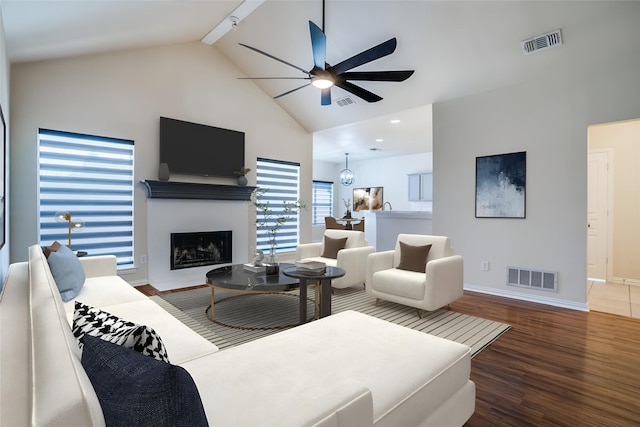 living room with dark hardwood / wood-style flooring, beamed ceiling, high vaulted ceiling, and ceiling fan