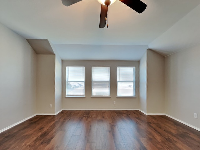 empty room with vaulted ceiling, a wealth of natural light, ceiling fan, and dark hardwood / wood-style flooring