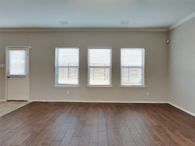 spare room with hardwood / wood-style floors, plenty of natural light, and ornamental molding