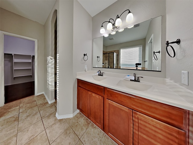 bathroom featuring tile patterned floors, a shower with shower door, and vanity