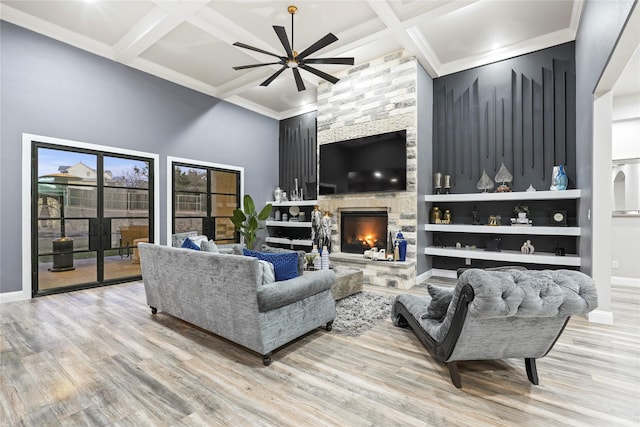 living room with light hardwood / wood-style flooring, a fireplace, coffered ceiling, and ceiling fan