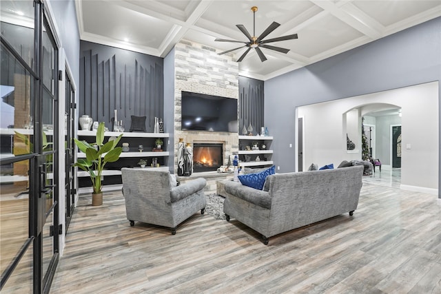 living room featuring hardwood / wood-style flooring, ceiling fan, coffered ceiling, a fireplace, and beamed ceiling