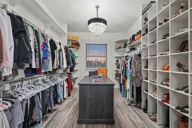 walk in closet featuring wood-type flooring and a notable chandelier