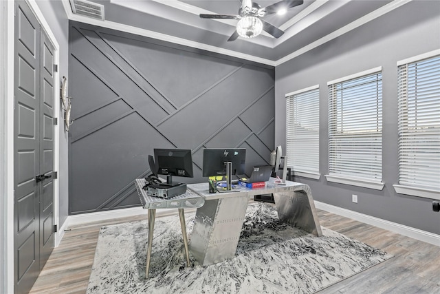 home office with hardwood / wood-style floors, ceiling fan, and a tray ceiling