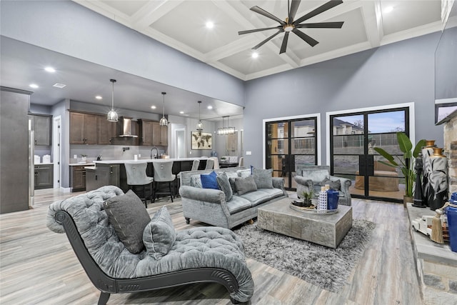 living room with ceiling fan, a towering ceiling, coffered ceiling, and beam ceiling