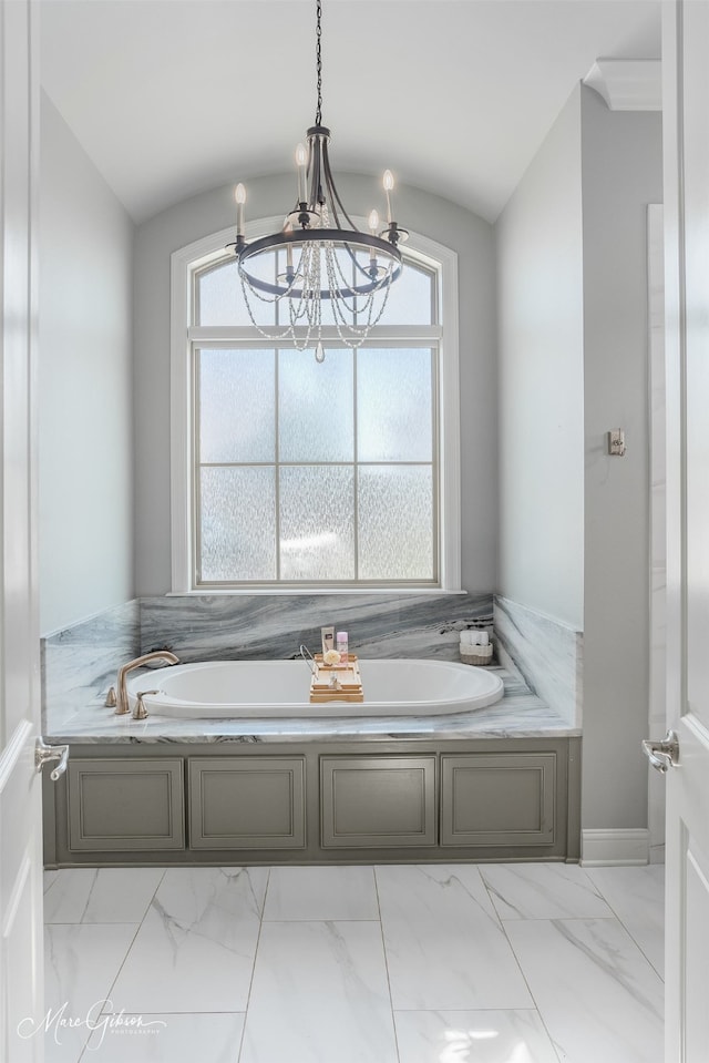 bathroom featuring lofted ceiling, a chandelier, and a bathtub