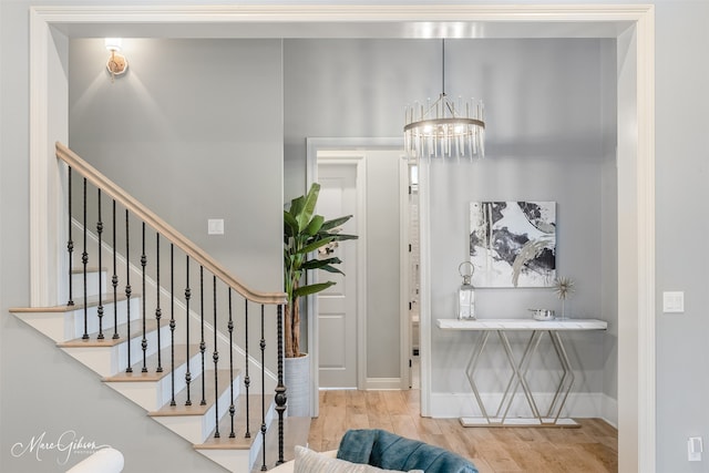 foyer entrance with wood-type flooring and a chandelier