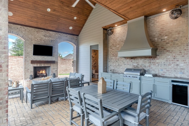 view of patio / terrace with an outdoor living space with a fireplace, an outdoor kitchen, grilling area, and sink