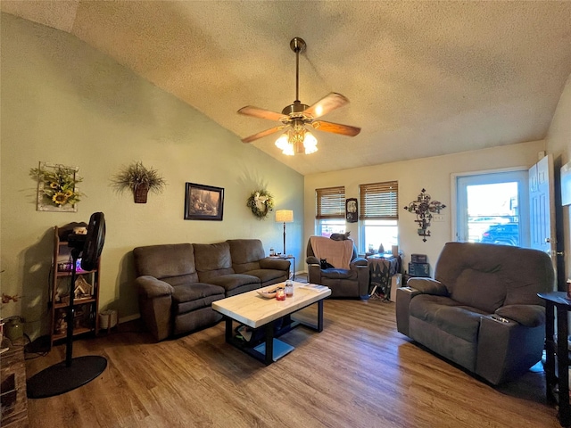 living room featuring lofted ceiling, ceiling fan, hardwood / wood-style flooring, and a textured ceiling