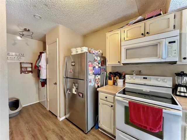 kitchen featuring white appliances, light hardwood / wood-style floors, and a textured ceiling