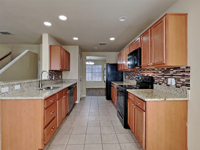 kitchen featuring sink, light stone counters, tasteful backsplash, light tile patterned floors, and black appliances