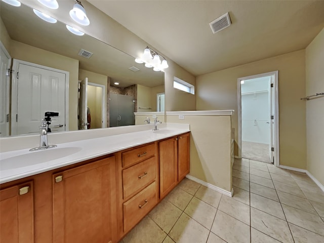 bathroom with tile patterned flooring, vanity, and a shower with shower door