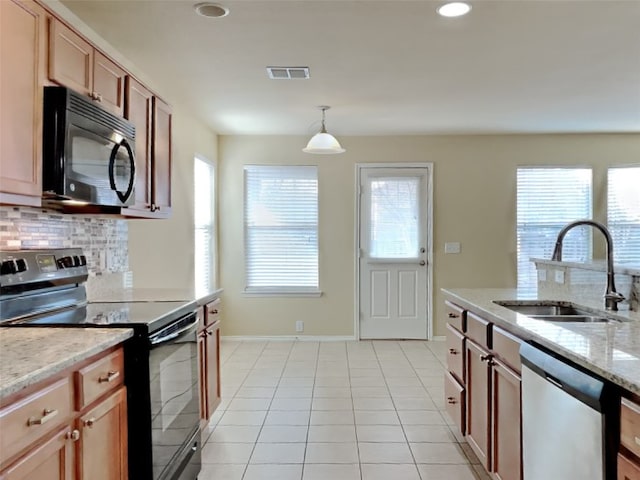 kitchen with sink, tasteful backsplash, black appliances, light tile patterned flooring, and decorative light fixtures