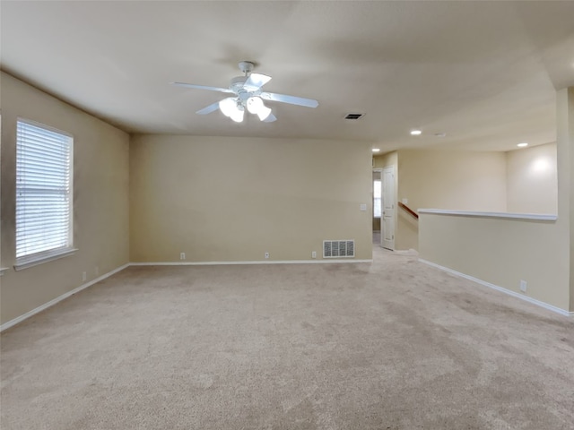 empty room featuring ceiling fan and light carpet