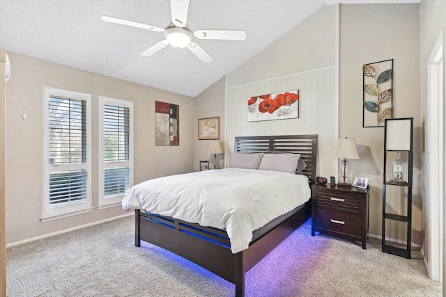 carpeted bedroom with ceiling fan and vaulted ceiling