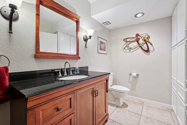 bathroom featuring vanity, tile patterned flooring, and toilet